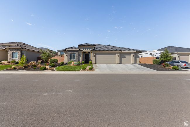 View of front of home with a garage, driveway, a tiled roof, stucco siding, and a residential view | Image 63