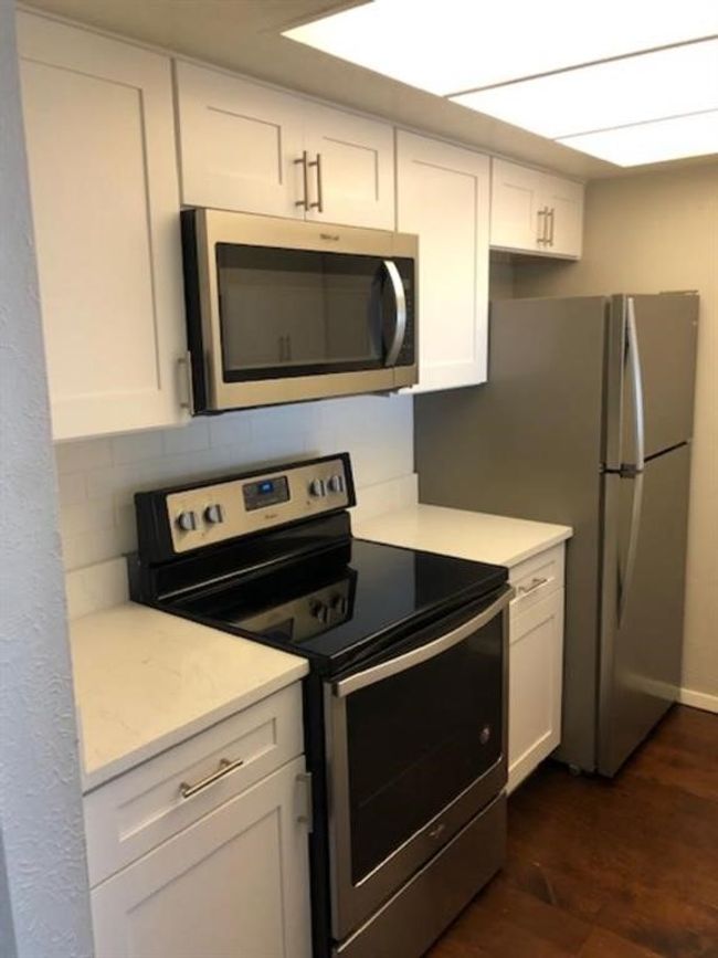 Kitchen with appliances with stainless steel finishes, light countertops, and white cabinetry | Image 19