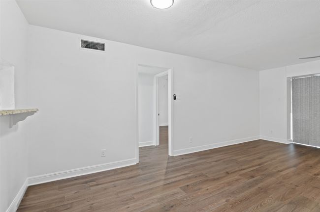 Large dining/living room with brand new flooring and sliding doors to patio area. | Image 5