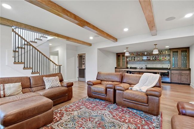 Living room with beam ceiling, recessed lighting, light wood-style floors, indoor wet bar, and beverage cooler | Image 42