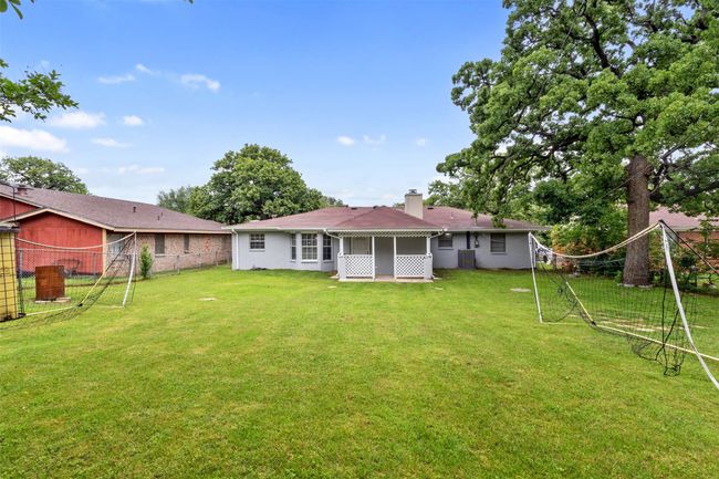 Rear view of property featuring a sunroom, fence, a yard, and a chimney | Image 25