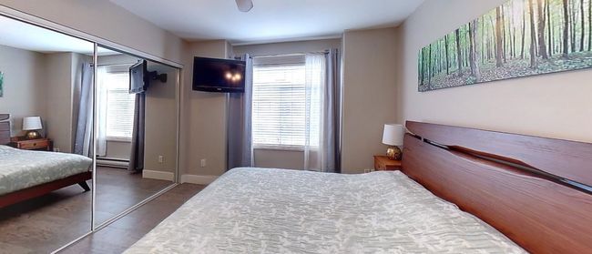 Bedroom featuring a baseboard heating unit, a closet, baseboards, and multiple windows | Image 12