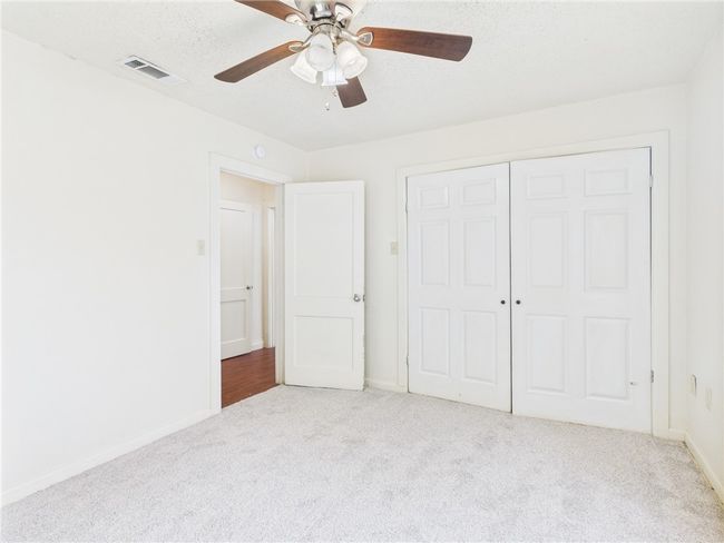 Unfurnished bedroom with carpet flooring, a closet, and a ceiling fan | Image 14