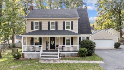 View of front facade with oversized garage, a front lawn, and country front porch | Image 1