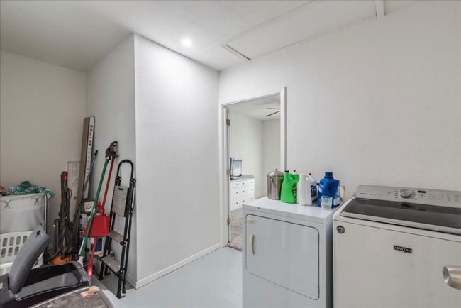 Clothes washing area featuring attic access, baseboards, washing machine and dryer, and laundry area | Image 19