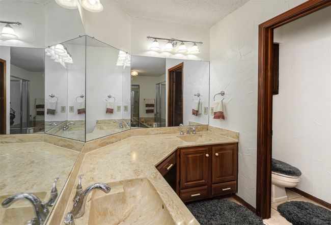 Full bath with a sink, a textured ceiling, double vanity, and toilet | Image 9
