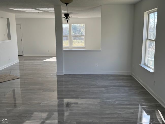 unfurnished living room with baseboards and ceiling fans | Image 5