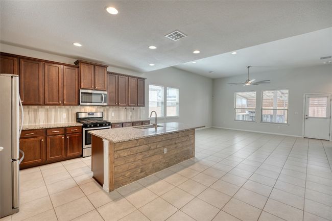 Kitchen with visible vents, a ceiling fan, a sink, stainless steel appliances, and light tile patterned flooring | Image 10