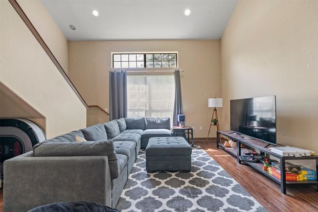 Living area with wood finished floors, recessed lighting, and stairs | Image 9