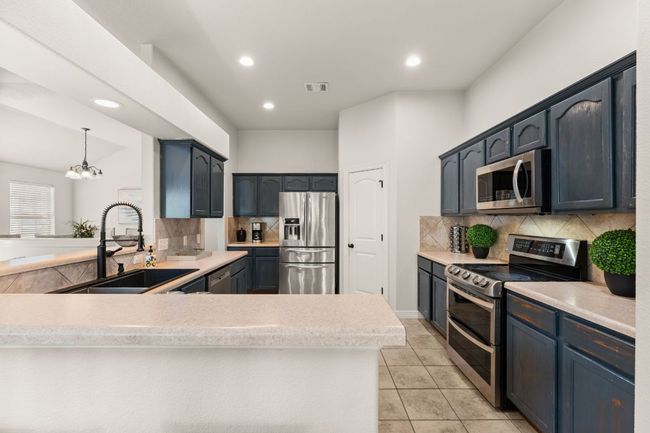 Kitchen with stainless steel appliances, a sink, tasteful backsplash, a peninsula, and recessed lighting | Image 9