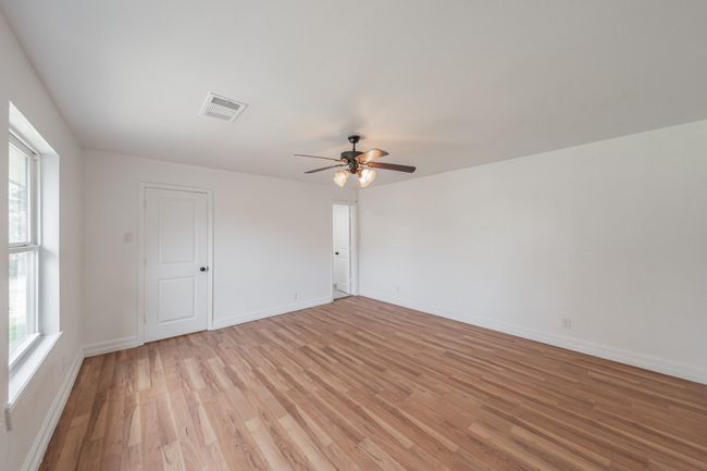 Empty room with light wood-type flooring, ceiling fan, healthy amount of natural light, and baseboards | Image 11