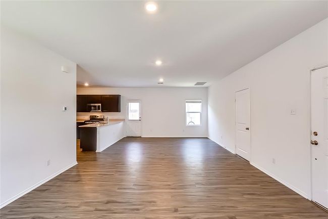Unfurnished living room featuring dark wood-style flooring, recessed lighting, and baseboards | Image 7
