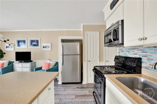 Full Sized Kitchen with Stainless Steel Appliances, Ceiling Height Cabinets, Island with Barstool Seating & Pantry. | Image 12
