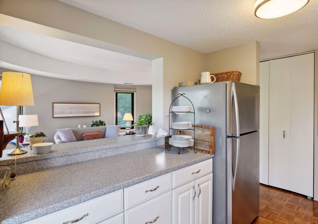 Thoughtfully updated kitchen with Corian countertops, stainless steel appliances, and newer cabinetry. | Image 8