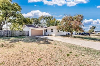 Ranch-style house with a front yard and a garage | Image 3