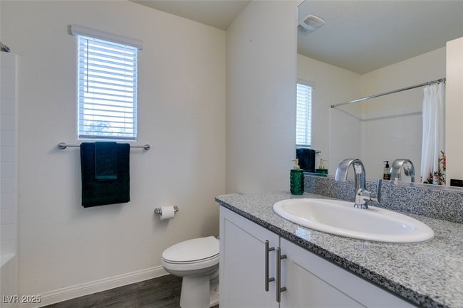 Full bath featuring a wealth of natural light, a shower with curtain, and wood finished floors | Image 20