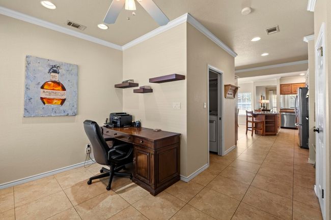 Home office featuring crown molding, a ceiling fan, and visible vents | Image 16