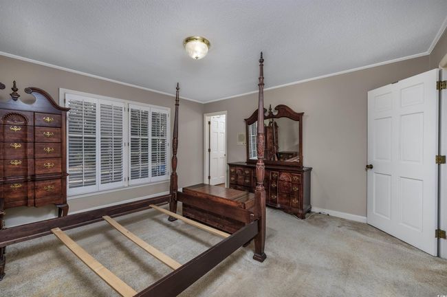 Carpeted bedroom featuring a textured ceiling and ornamental molding | Image 22