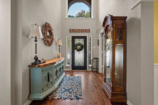 Entryway featuring a textured wall, dark wood-type flooring, and a high ceiling | Image 5