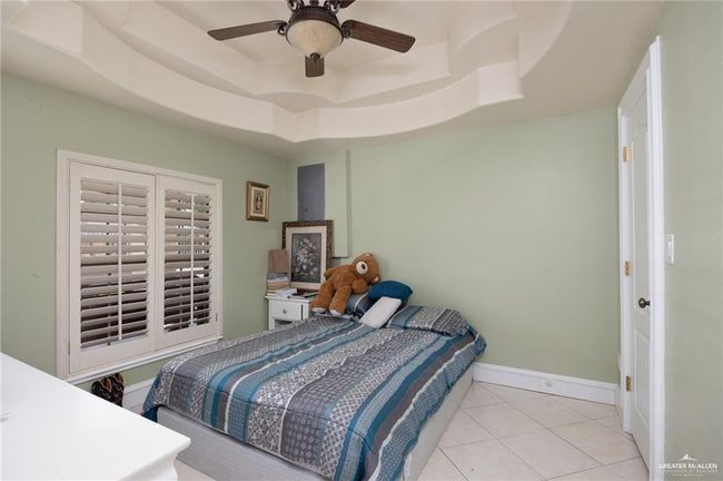 Tiled bedroom with a raised ceiling and ceiling fan | Image 6