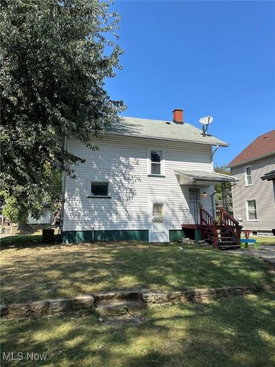 Rear view of house with a lawn and cooling unit | Image 2