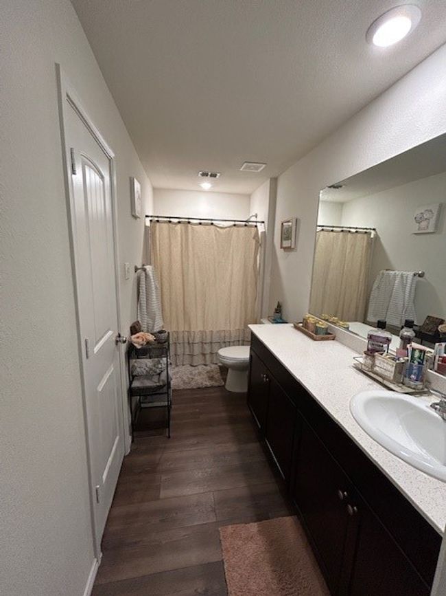 Featuring tub-shower combo, stone counter and vinyl flooring. Huge walkin closet is on the right. | Image 12