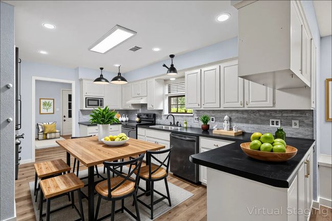Virtual staged : Kitchen featuring dishwashing machine, electric range oven, stainless steel microwave, dark countertops, and light wood-style floors | Image 4