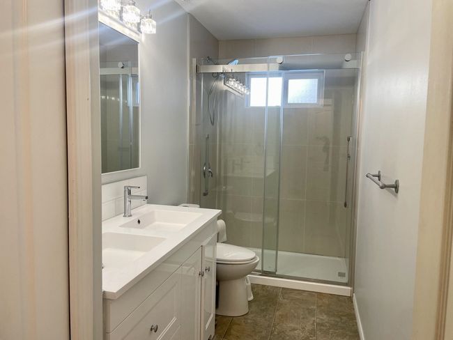 Full bath featuring toilet, vanity, a stall shower, and baseboards | Image 40