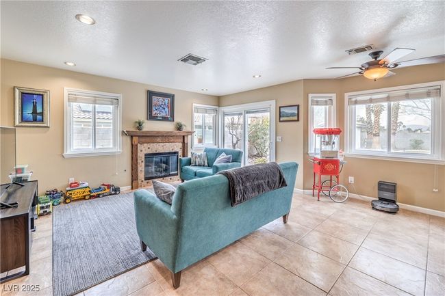 Living room with a fireplace, wealth of natural light, and a ceiling fan | Image 13