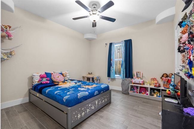 Bedroom with wood finished floors and ceiling fan | Image 28