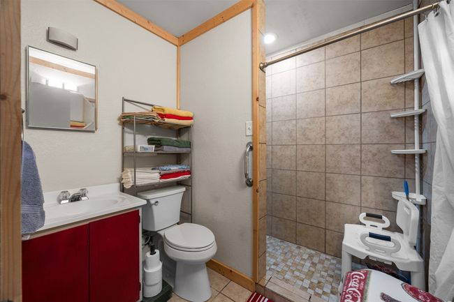 Full bathroom with updated tiled shower, vanity, toilet, and tile patterned floors | Image 10