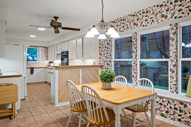 Dining room featuring light tile flooring and ceiling fan with 3 large windows | Image 14