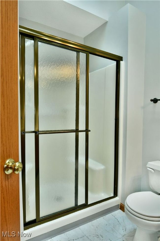 Full bath featuring marble look tile flooring and a shower stall | Image 33