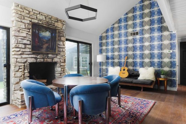 Dining space with wood finished floors, a stone fireplace, lofted ceiling, and visible vents | Image 13
