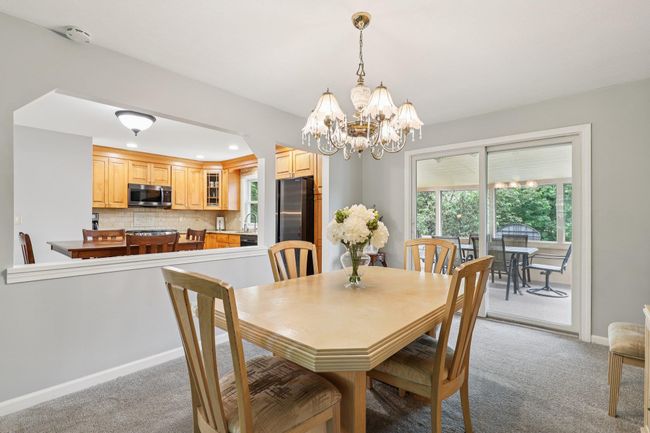 Dining area featuring light carpet, a chandelier, and recessed lighting | Image 6