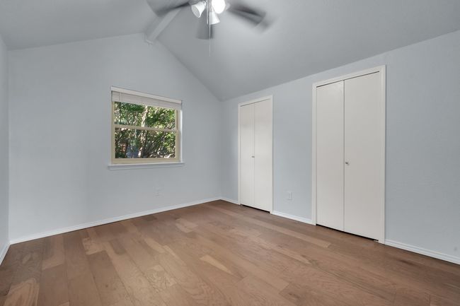 Unfurnished bedroom featuring multiple closets, wood finished floors, and ceiling fan | Image 20