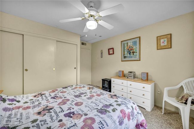 Bedroom featuring light carpet, a ceiling fan, visible vents, and a closet | Image 36
