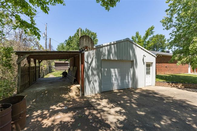 Garage featuring concrete driveway and a detached garage | Image 11