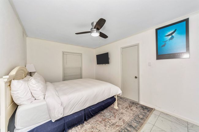 Bedroom with a ceiling fan, light marble finish flooring, and baseboards | Image 16
