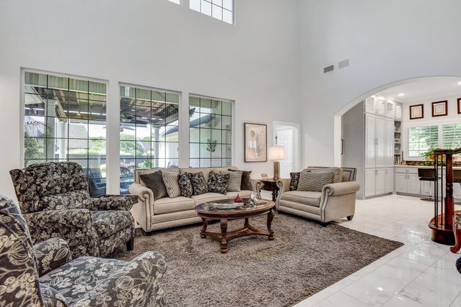 Living area with arched walkways, light marble finish floors, and a towering ceiling | Image 11