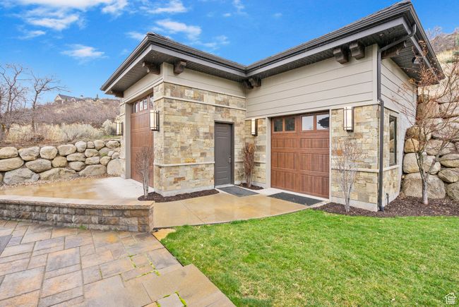 Doorway to property with a yard and stone siding | Image 90