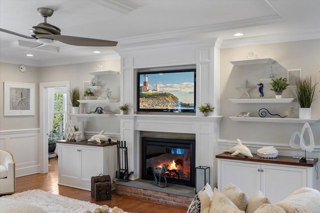 Living room with wood finished floors, ornamental molding, and ceiling fan | Image 18