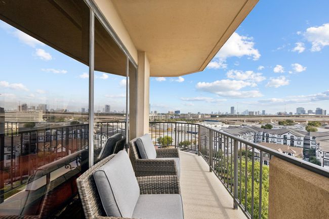 Spacious balcony featuring a panoramic, urban skyline view, perfect for outdoor relaxation and entertaining. | Image 27