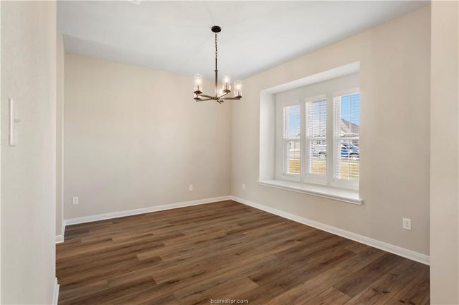 dining area with a chandelier and wood finished floors | Image 5