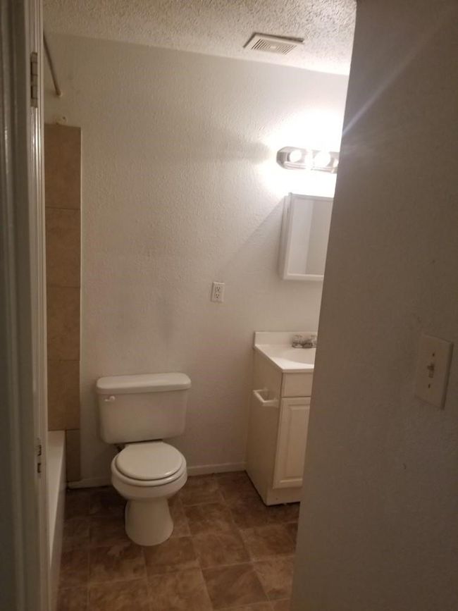 Bathroom featuring vanity, toilet, and a textured ceiling | Image 7