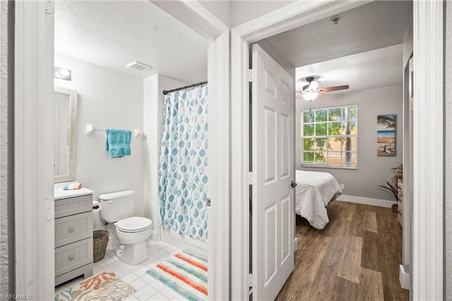 Ensuite bathroom featuring vanity, a textured ceiling, ceiling fan, and visible vents | Image 12
