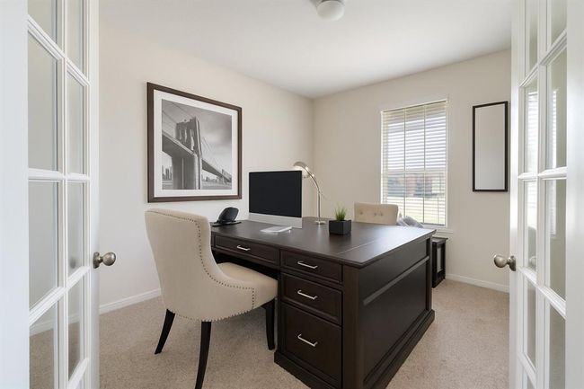 The home office is a perfect blend of functionality and comfort, featuring a window with privacy blinds and plush carpet flooring. | Image 6
