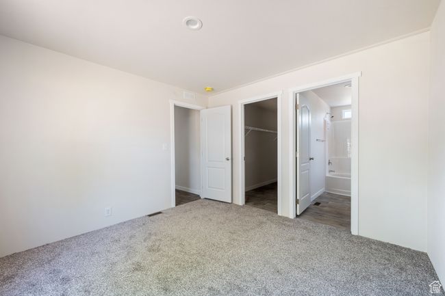 Unfurnished bedroom with carpet floors, a spacious closet, a closet, and connected bathroom | Image 10