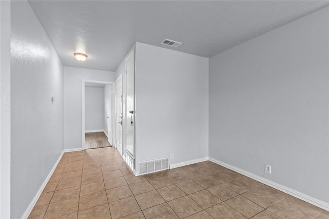 Empty room with light tile patterned floors and baseboards | Image 11