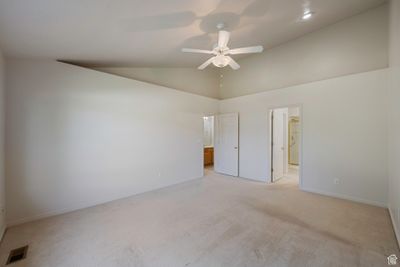 Unfurnished bedroom featuring light carpet, ceiling fan, and high vaulted ceiling | Image 3